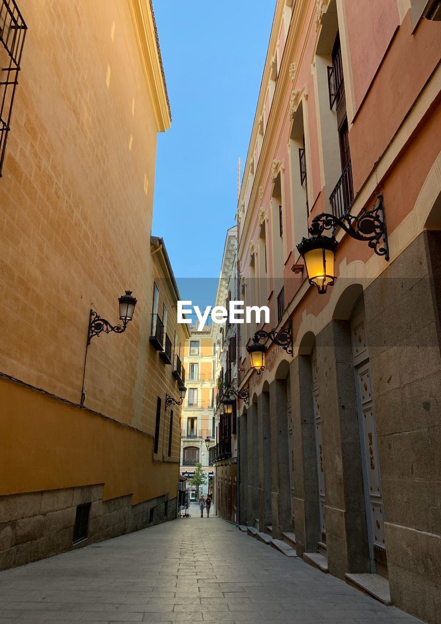 Low angle view of street amidst buildings against sky