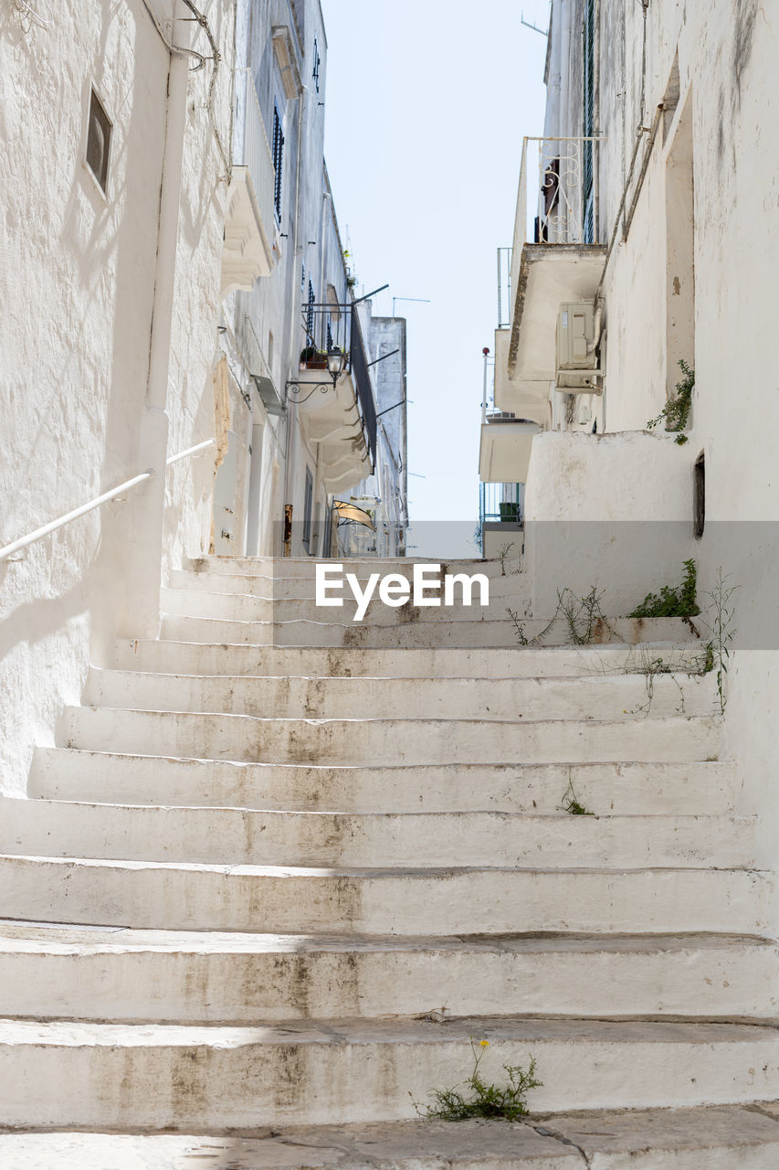 A beautiful view of the whitewashed street staircase in the city of ostuni.