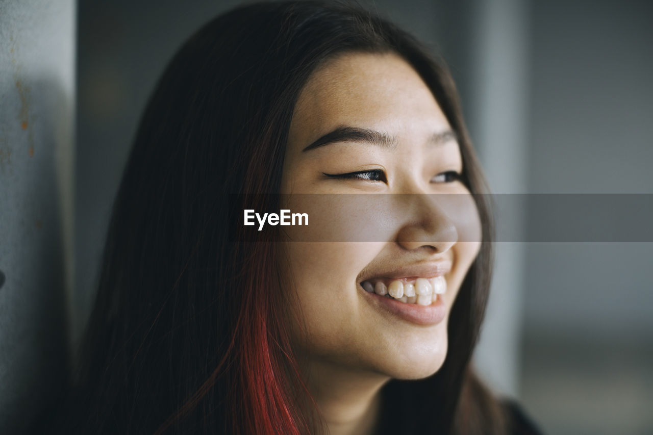 Smiling female teenager looking away