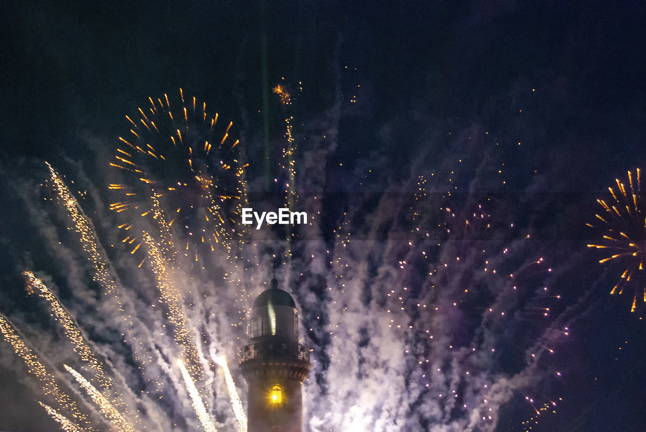 Low angle view of firework display at night