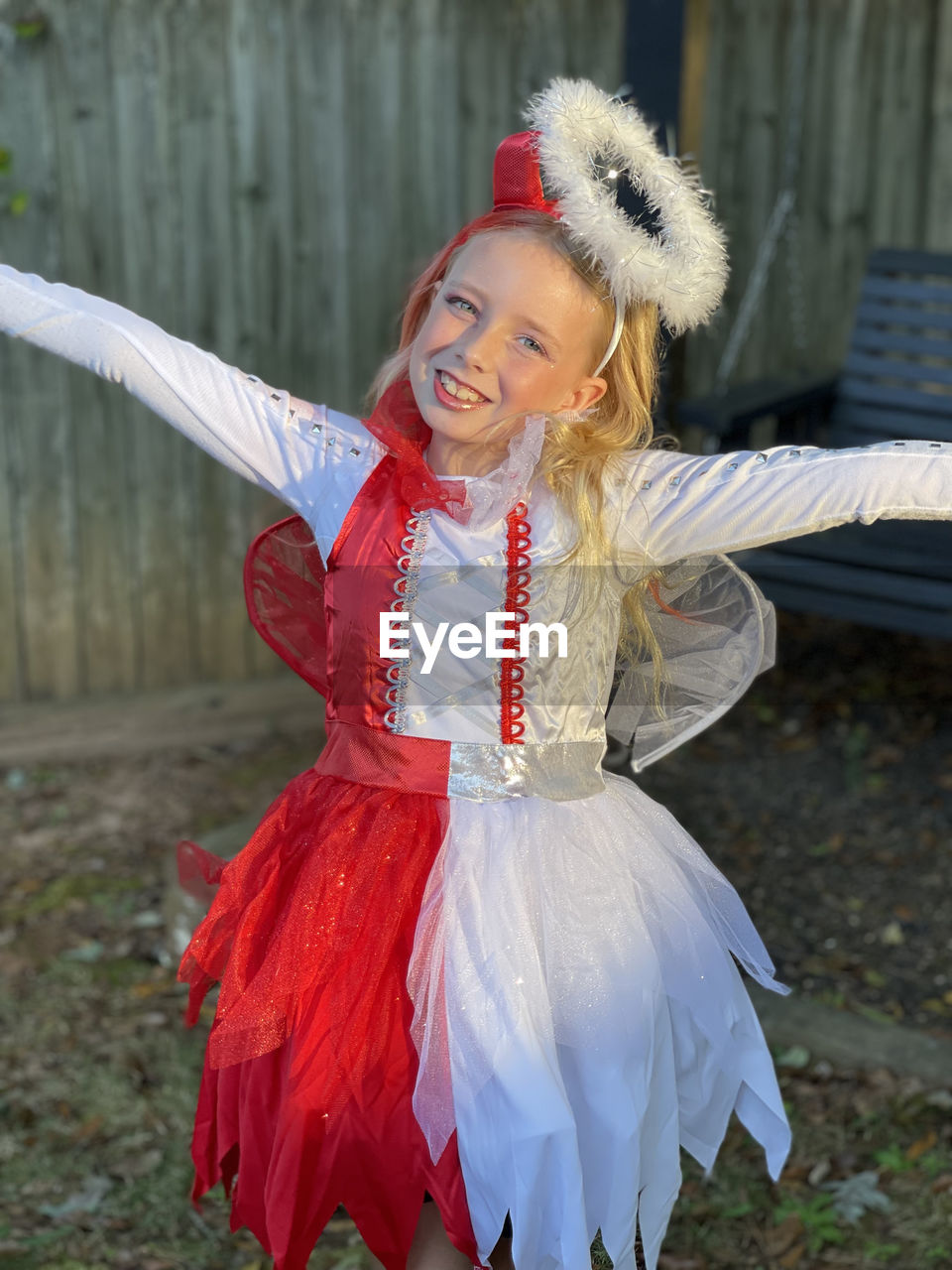 Portrait of young woman standing outside in halloween costume of half angel half devil 