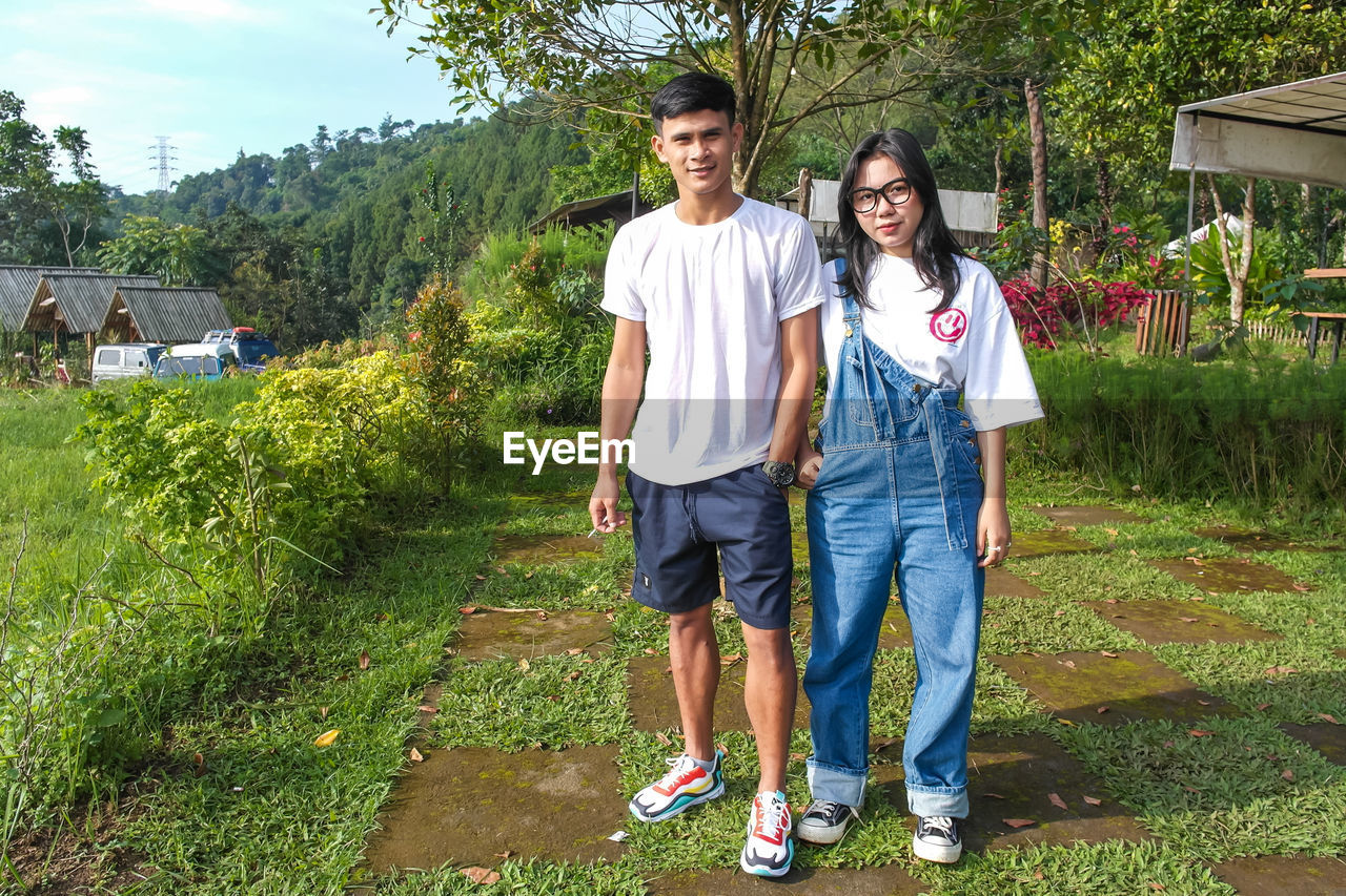 Portrait of young boy and girl standing on field