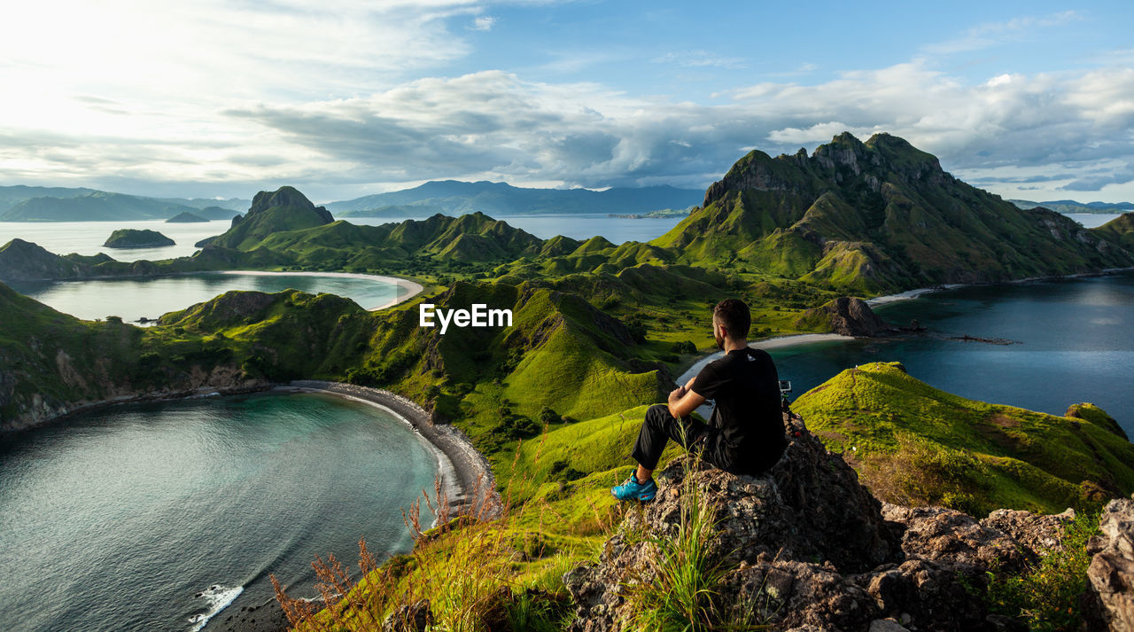 A man sitting on the rock on top of padar island