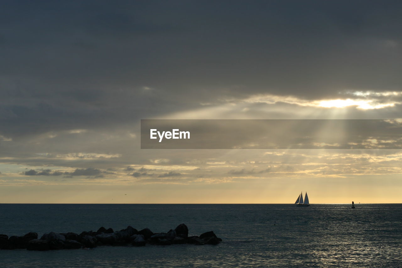 Scenic view of sea against cloudy sky during sunset