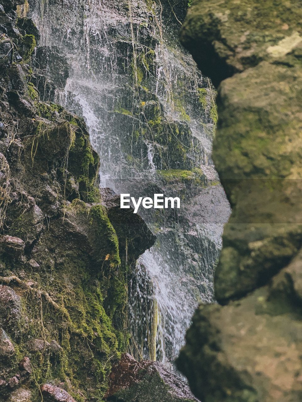 SCENIC VIEW OF WATERFALL ON ROCK FORMATION