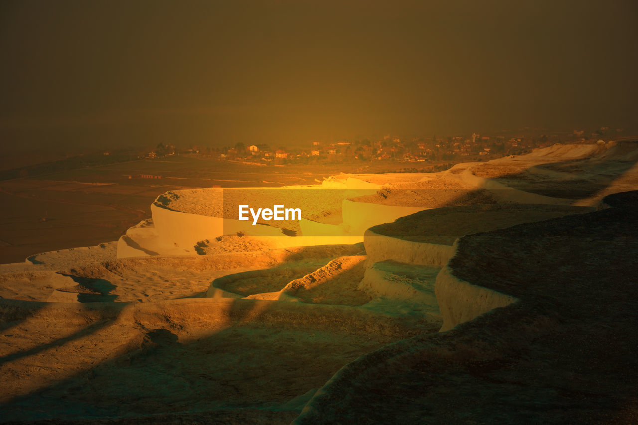 HIGH ANGLE VIEW OF LANDSCAPE AGAINST SKY DURING SUNSET