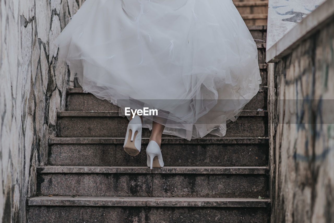 Low section of bride moving up on staircase