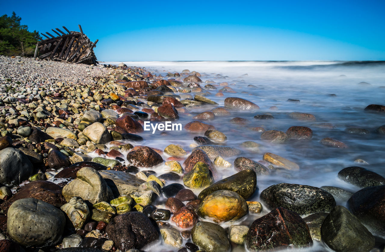 Pebbles on beach against sky