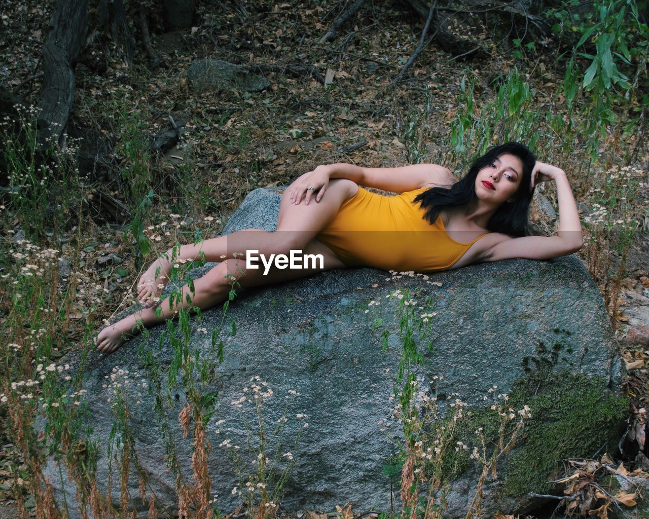 High angle portrait of woman lying on rock