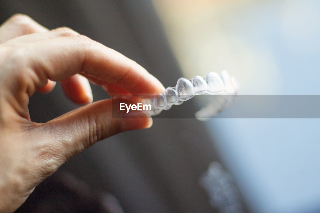 Cropped hand holding dentures