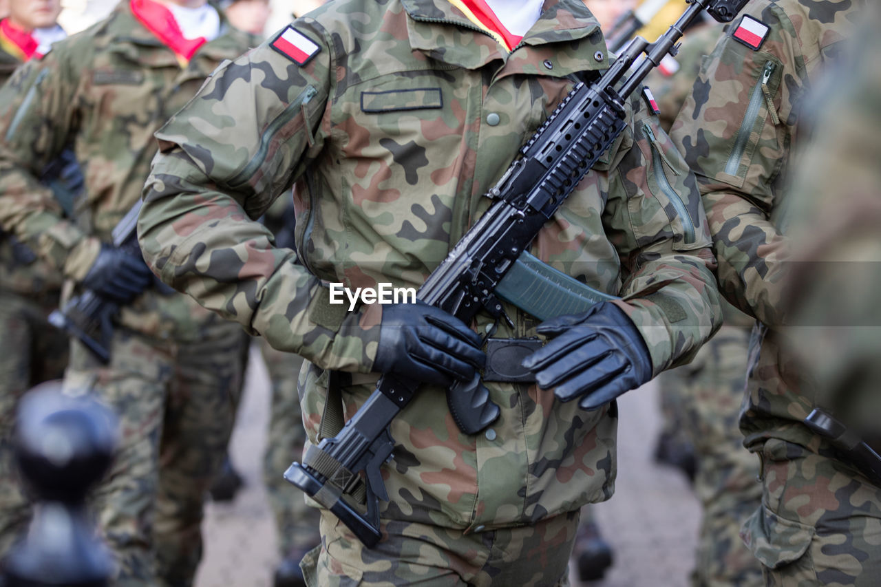 Armed polish soldiers with machine guns are marching.