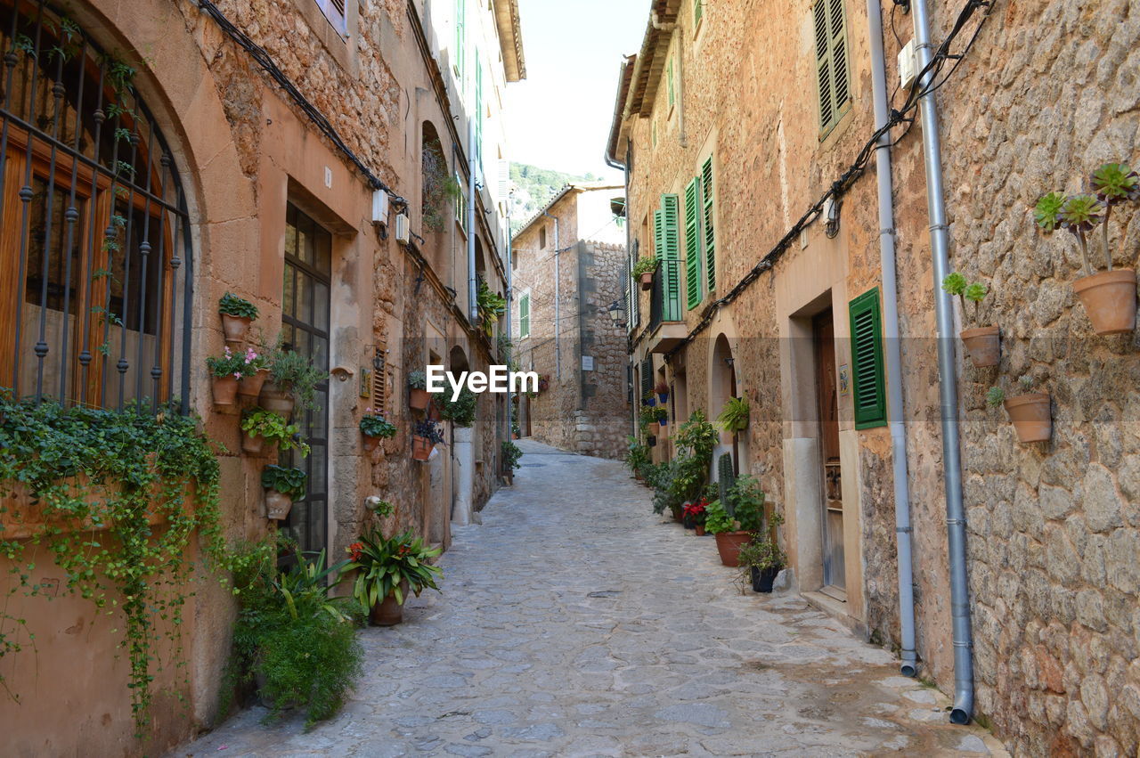 Narrow alley amidst old buildings. old town of valldemossa, mallorca, spain.