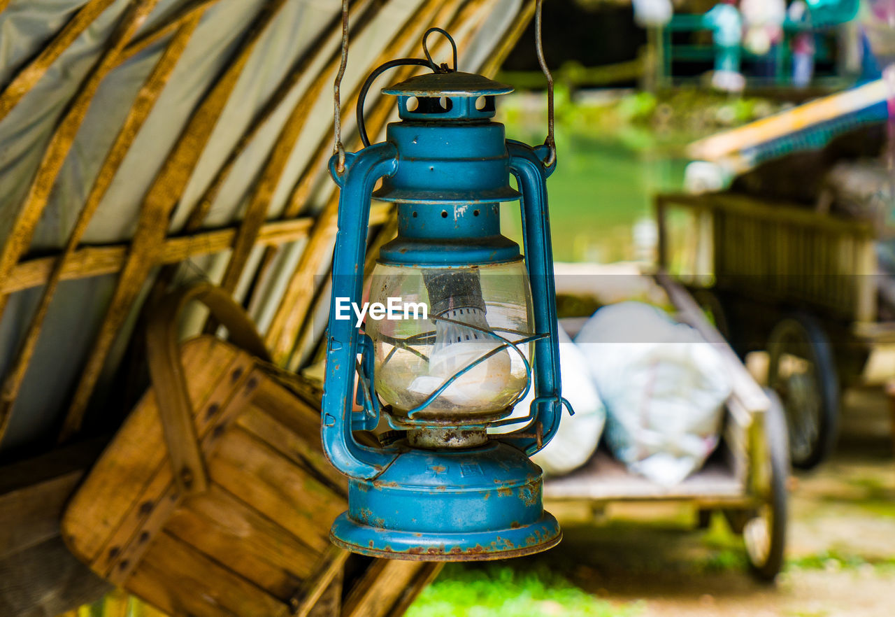 focus on foreground, no people, wood, vehicle, lighting, outdoors, nature, day, lighting equipment, container, green, lantern, metal, transportation