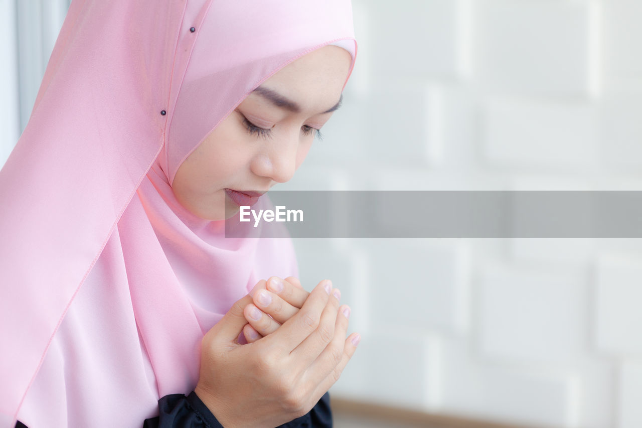 Close-up of woman praying at home