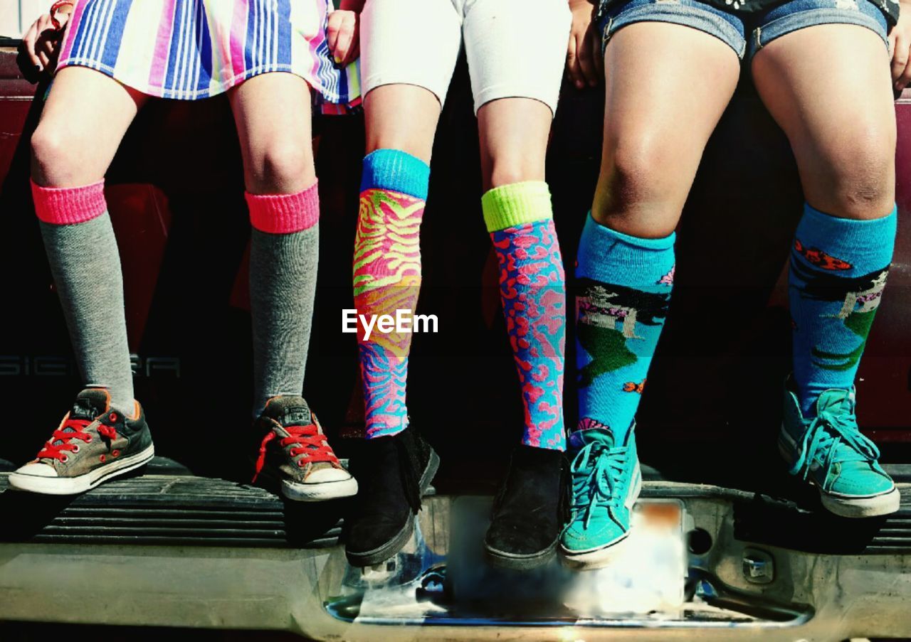 Low section of friends wearing colorful socks