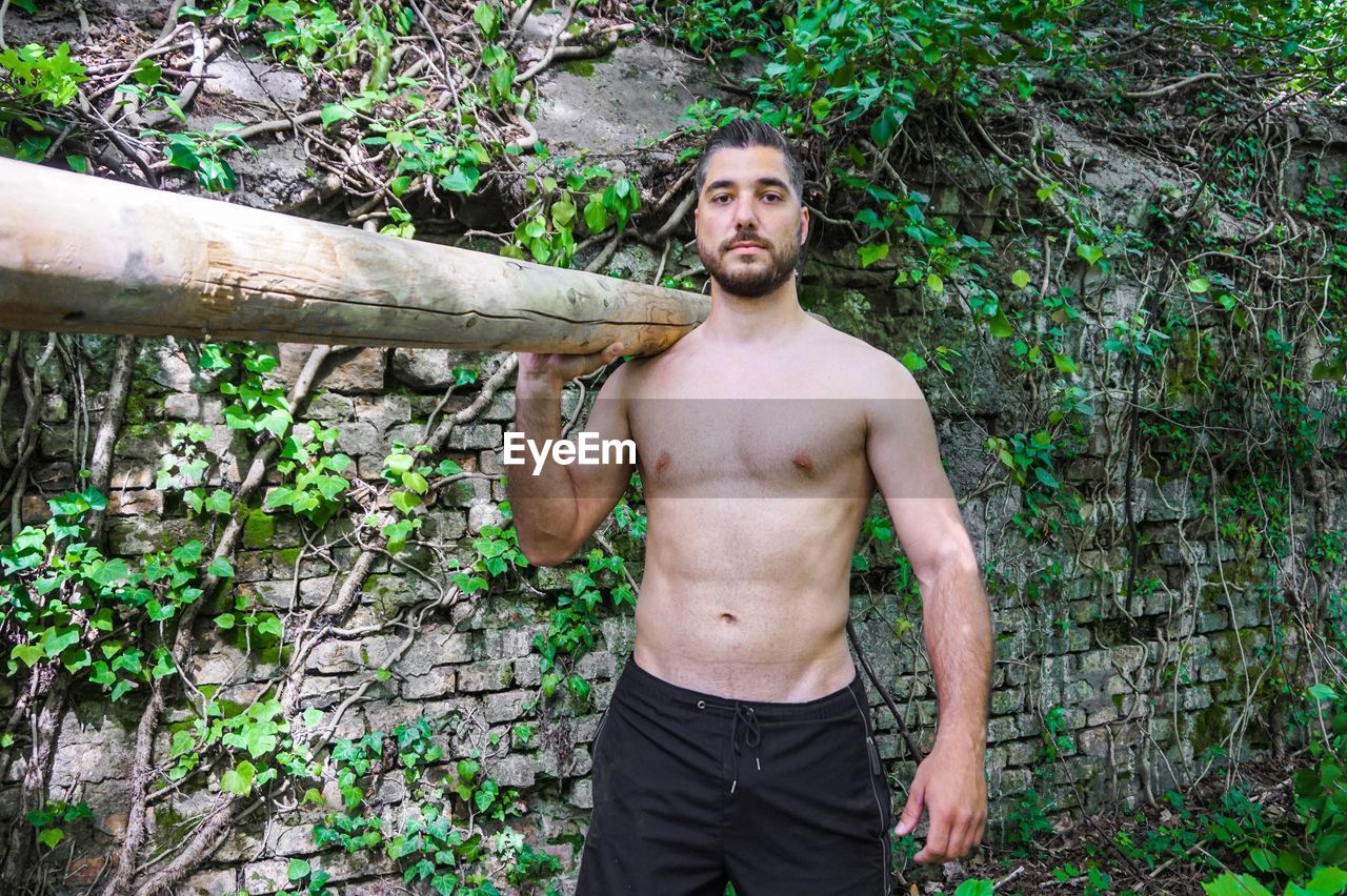 Portrait of young man carrying wood