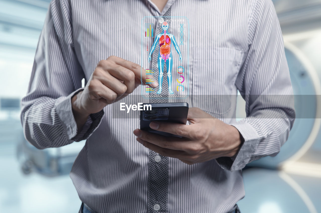 adult, holding, one person, technology, occupation, indoors, front view, healthcare and medicine, midsection, business, men, shirt, business finance and industry, standing, mature adult, person, science, finance, communication, focus on foreground, research, innovation