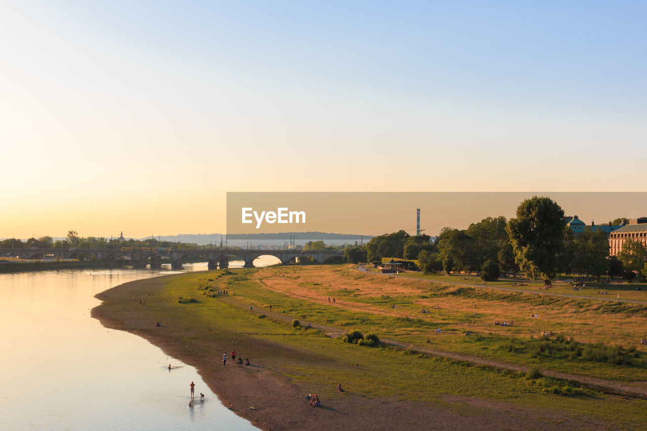 SCENIC VIEW OF RIVER AGAINST SKY AT SUNSET