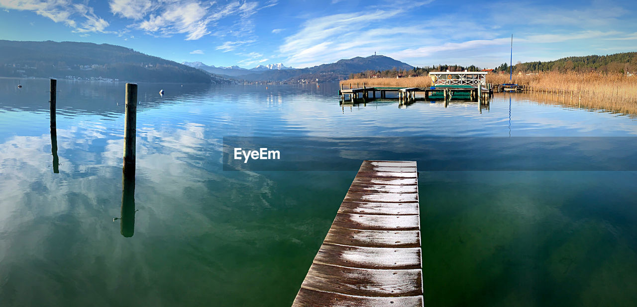 Wooden pier on lake against sky