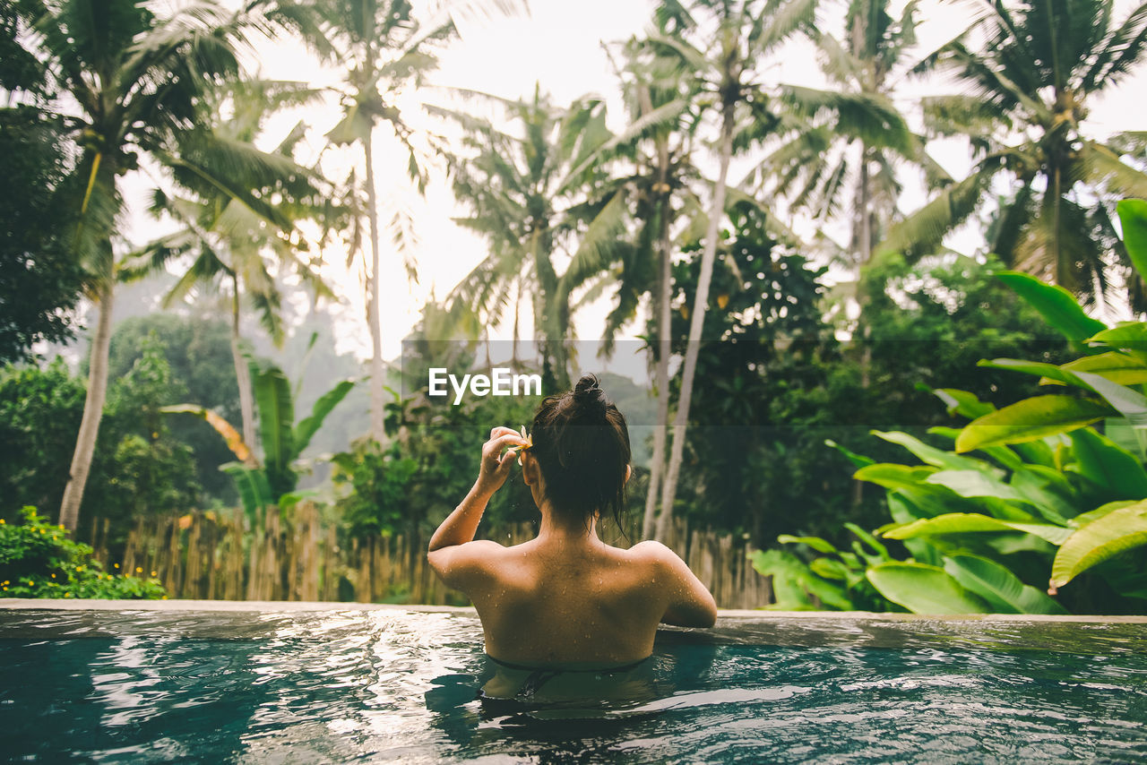 Rear view of shirtless woman in swimming pool