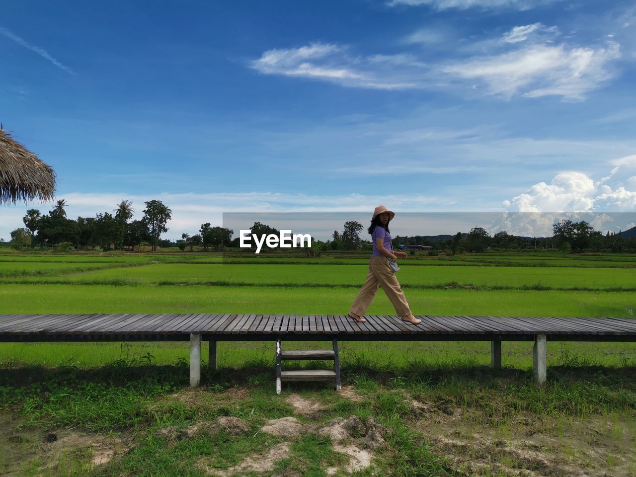 Full length of woman walking on field against sky