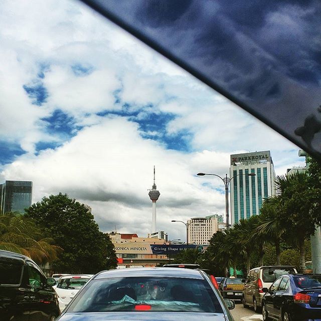 LOW ANGLE VIEW OF MODERN BUILDINGS AGAINST CLOUDY SKY