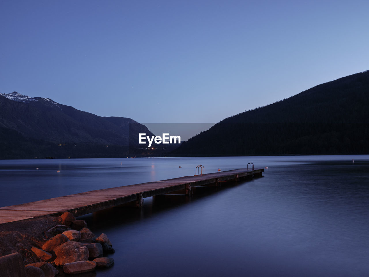 SCENIC VIEW OF LAKE AGAINST CLEAR SKY AT DUSK