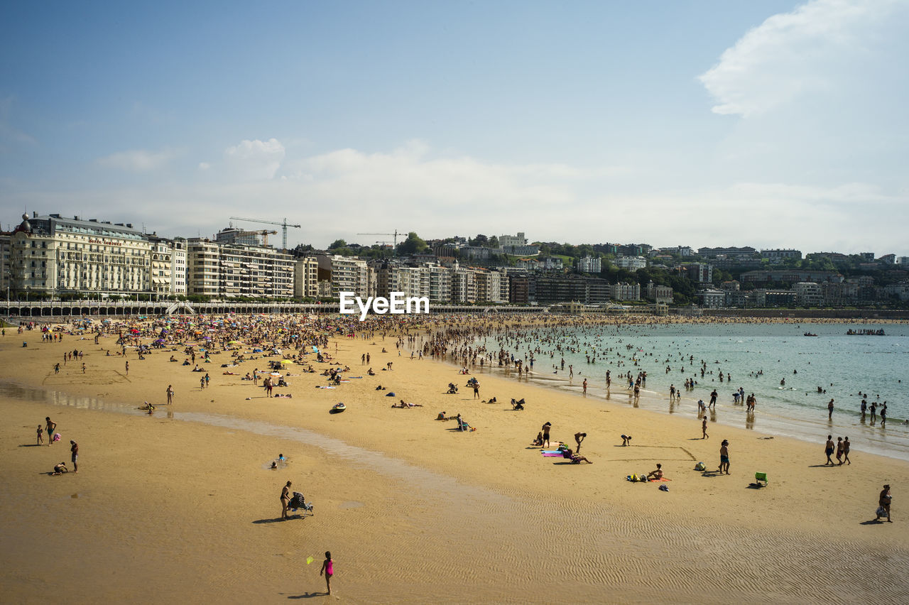 Group of people on beach against sky