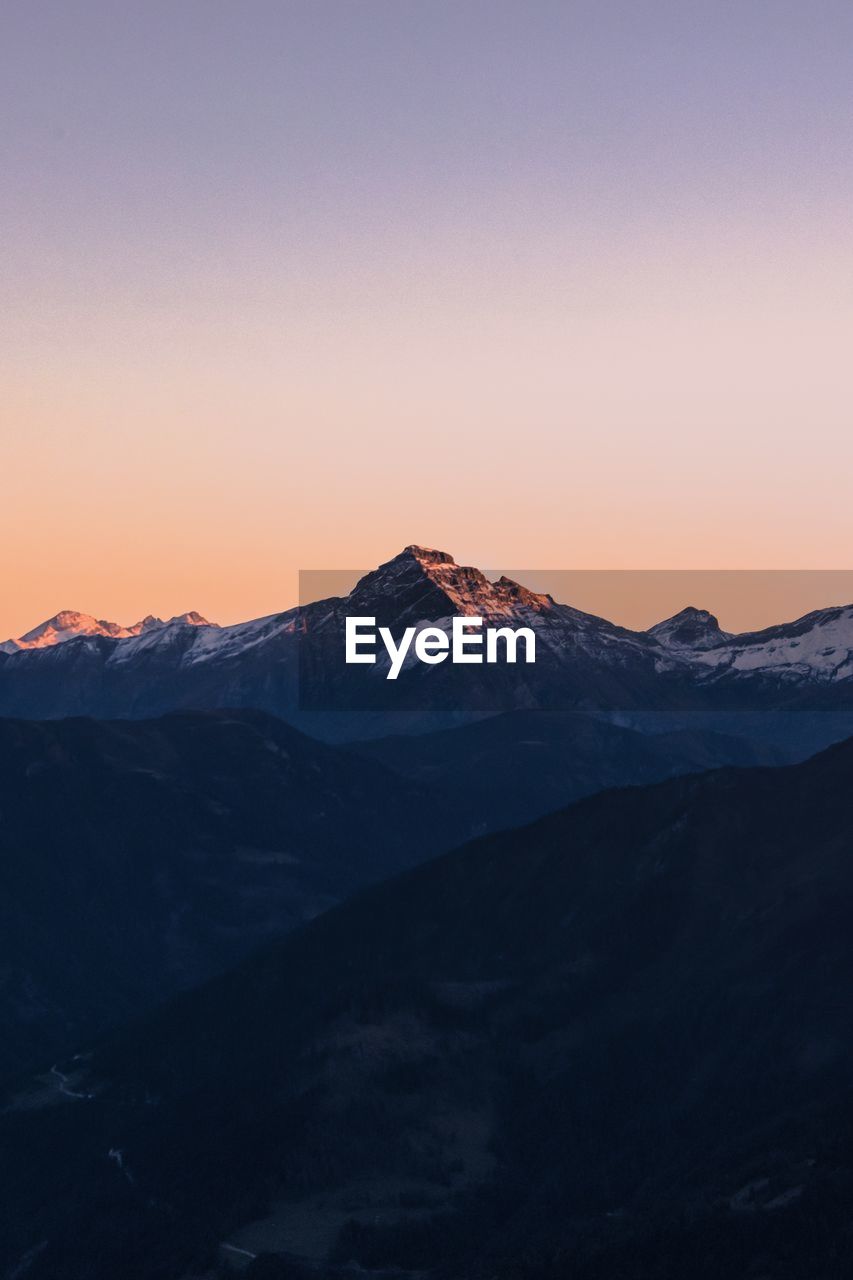 Scenic view of snowcapped mountains against sky during sunset