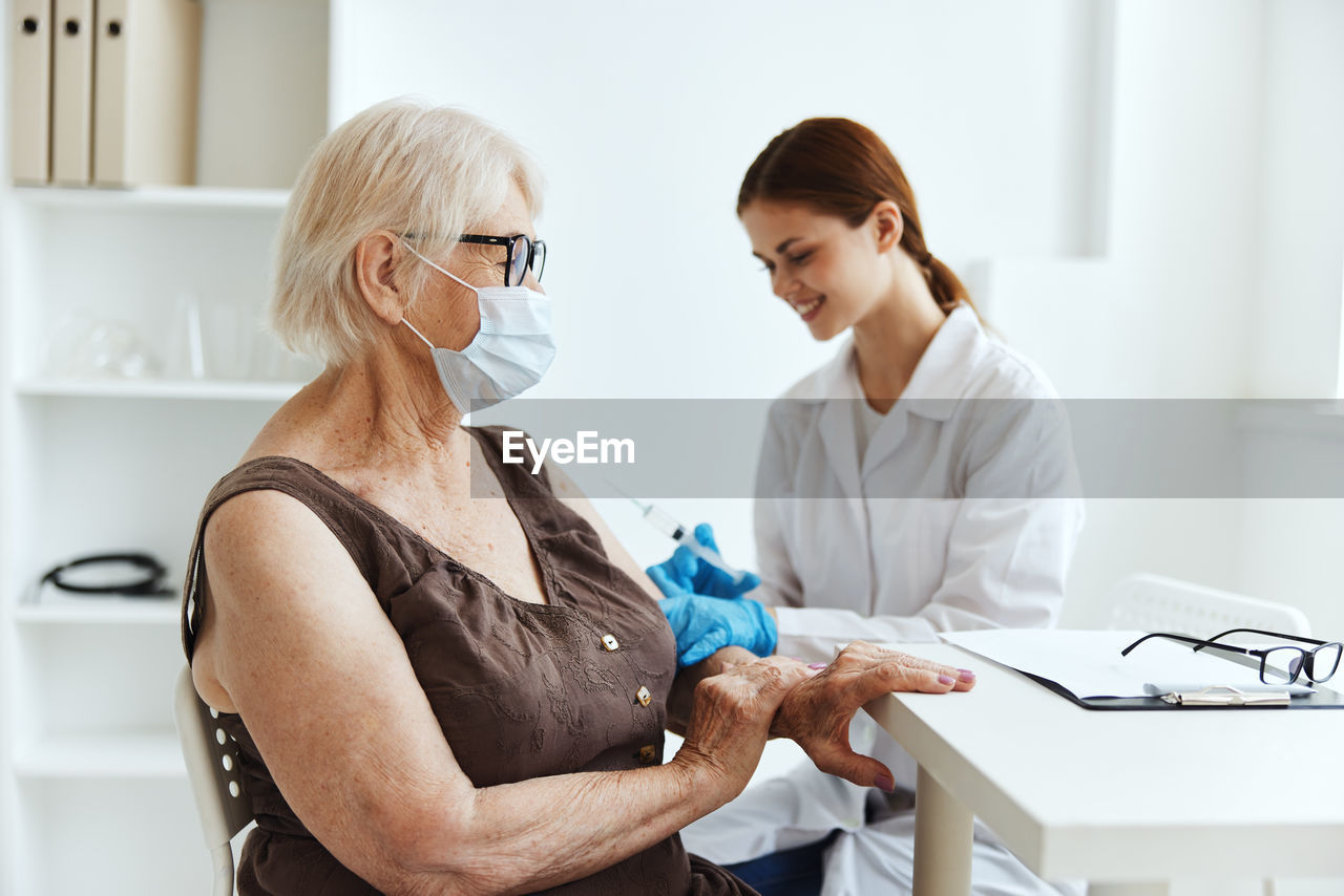 WOMAN IN FRONT OF TWO PEOPLE IN A OFFICE