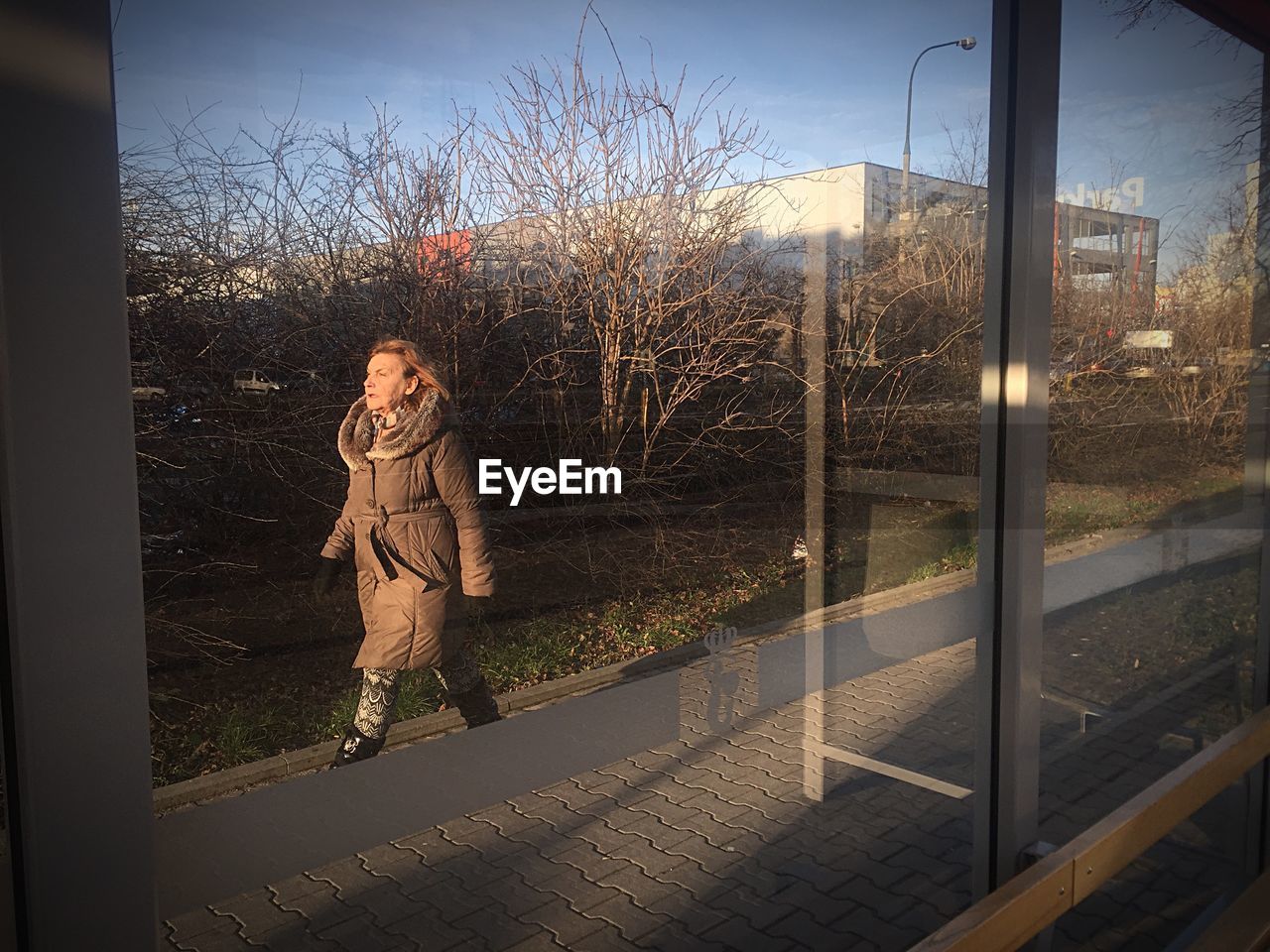 FULL LENGTH OF WOMAN USING PHONE AGAINST SKY