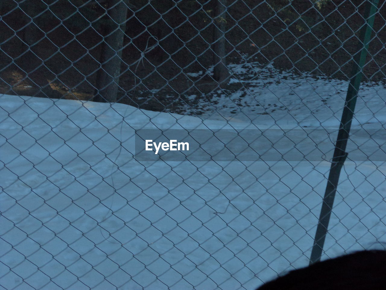 CLOSE-UP OF CHAINLINK FENCE AGAINST METAL