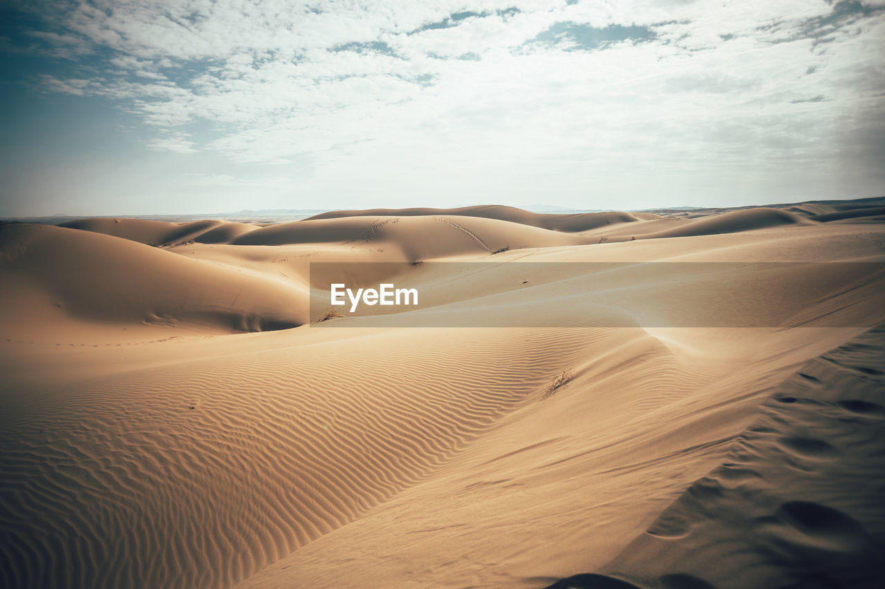 Sand dunes in desert against sky