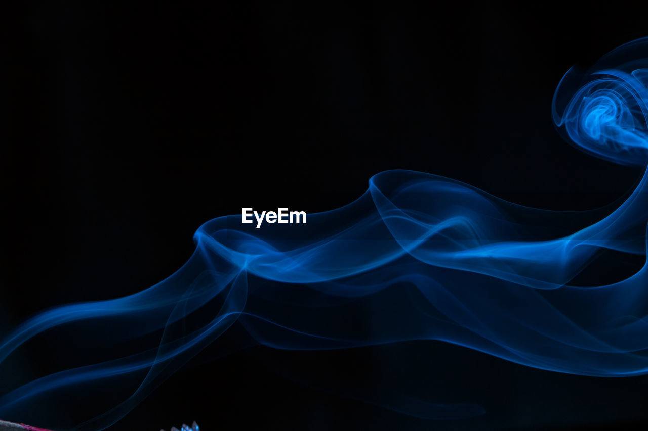 Close-up of blue smoke against black background