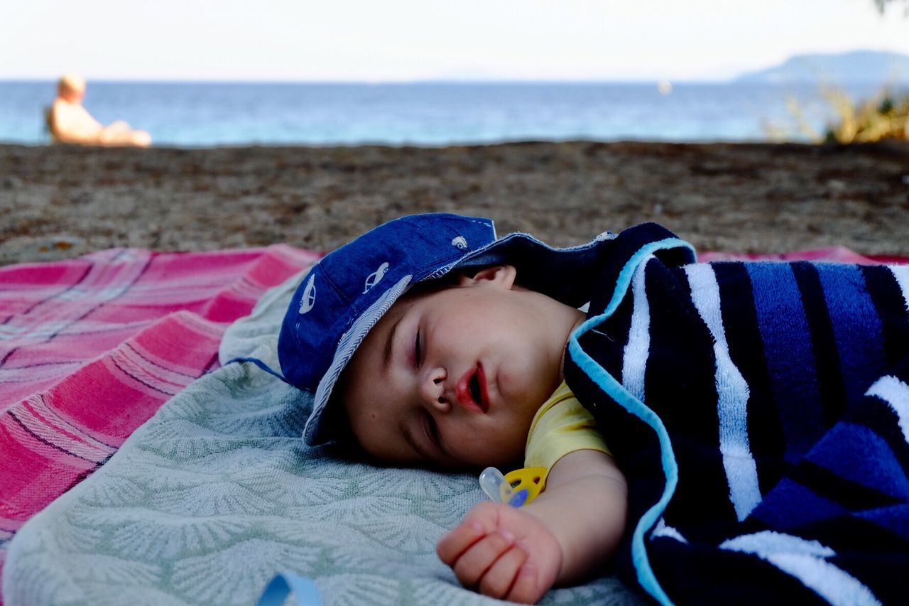 Cute baby boy sleeping at beach