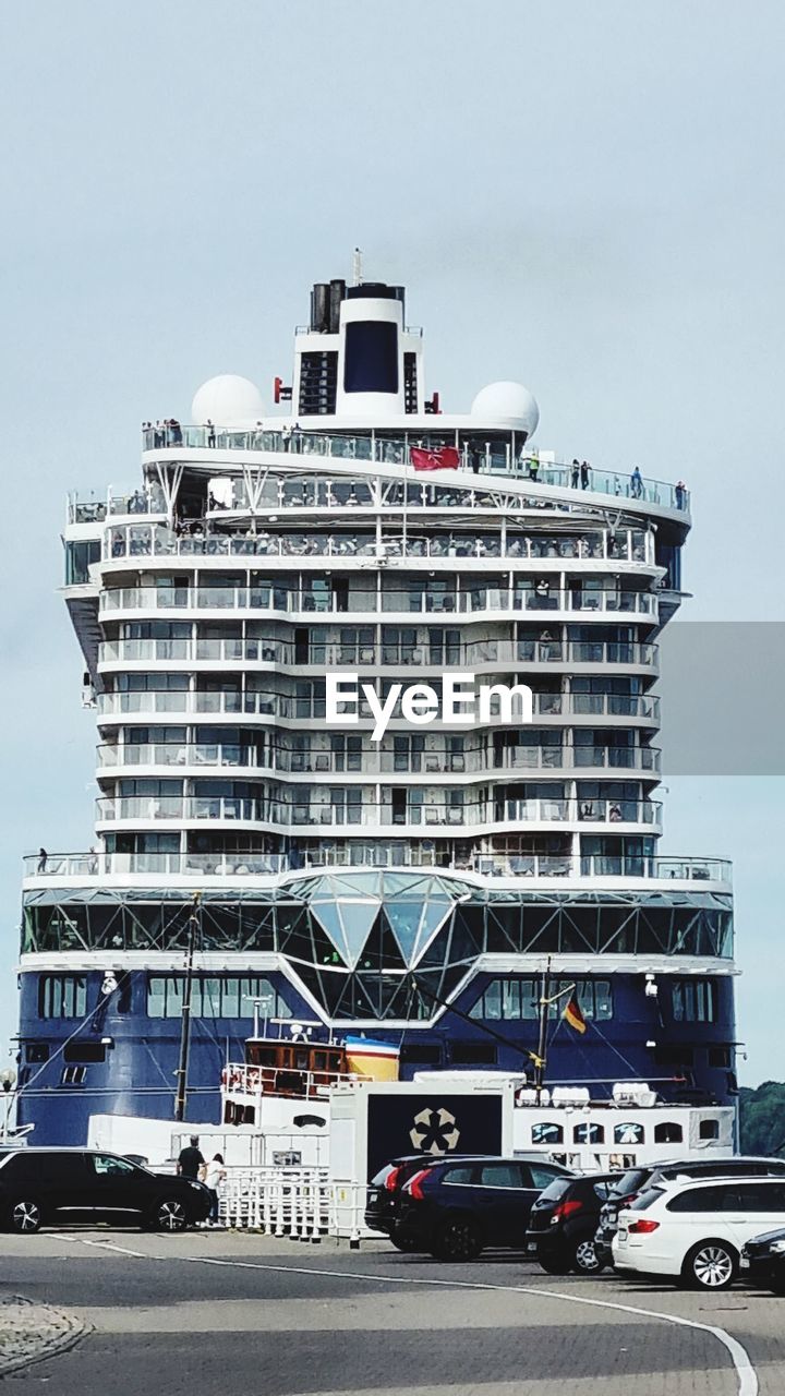 passenger ship, vehicle, cruise ship, transportation, architecture, ship, mode of transportation, car, city, building exterior, built structure, freight transport, ferry, watercraft, ocean liner, motor vehicle, sky, industry, business finance and industry, nature, boat, no people, travel, building, land vehicle, construction industry, outdoors, road, naval architecture, day, motor ship, water, truck