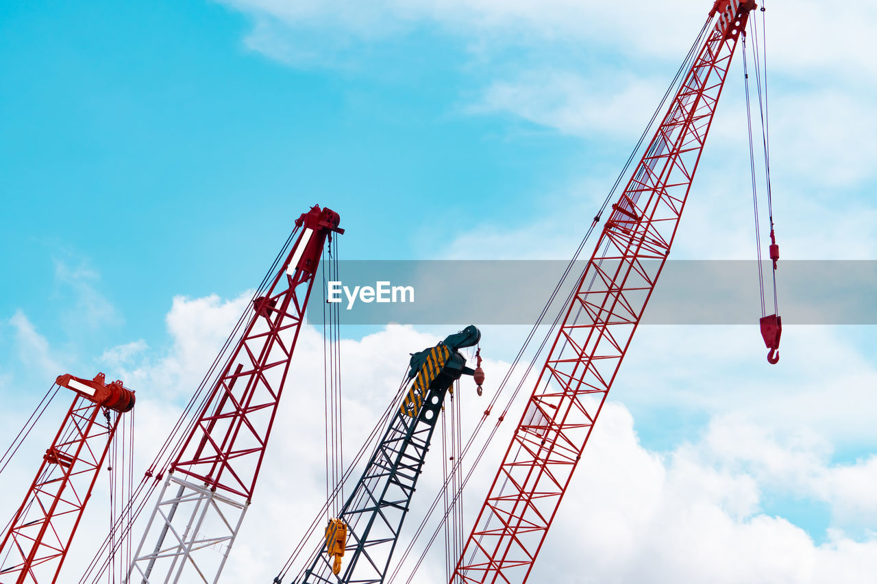 Crawler crane against blue sky and white clouds. real estate industry. red crawler crane.