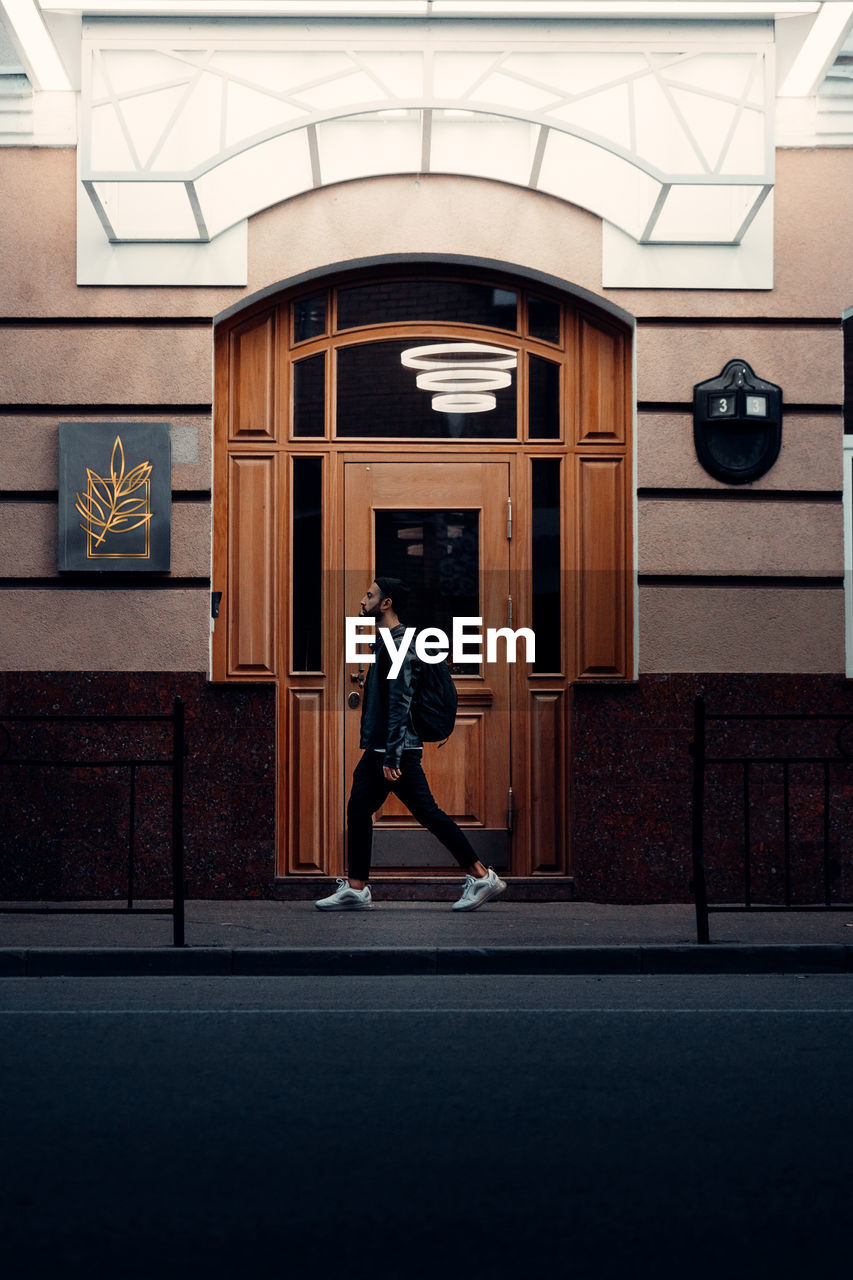 Full length side view of a man walking in corridor