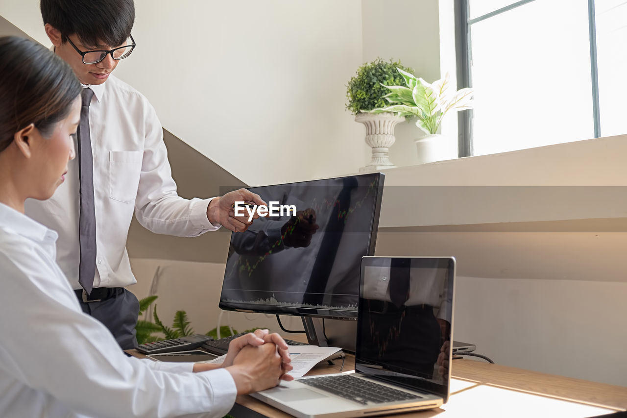 MIDSECTION OF WOMAN WORKING WITH LAPTOP IN RESTAURANT