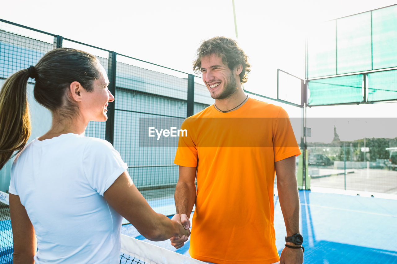 Man and woman shaking hands outdoors