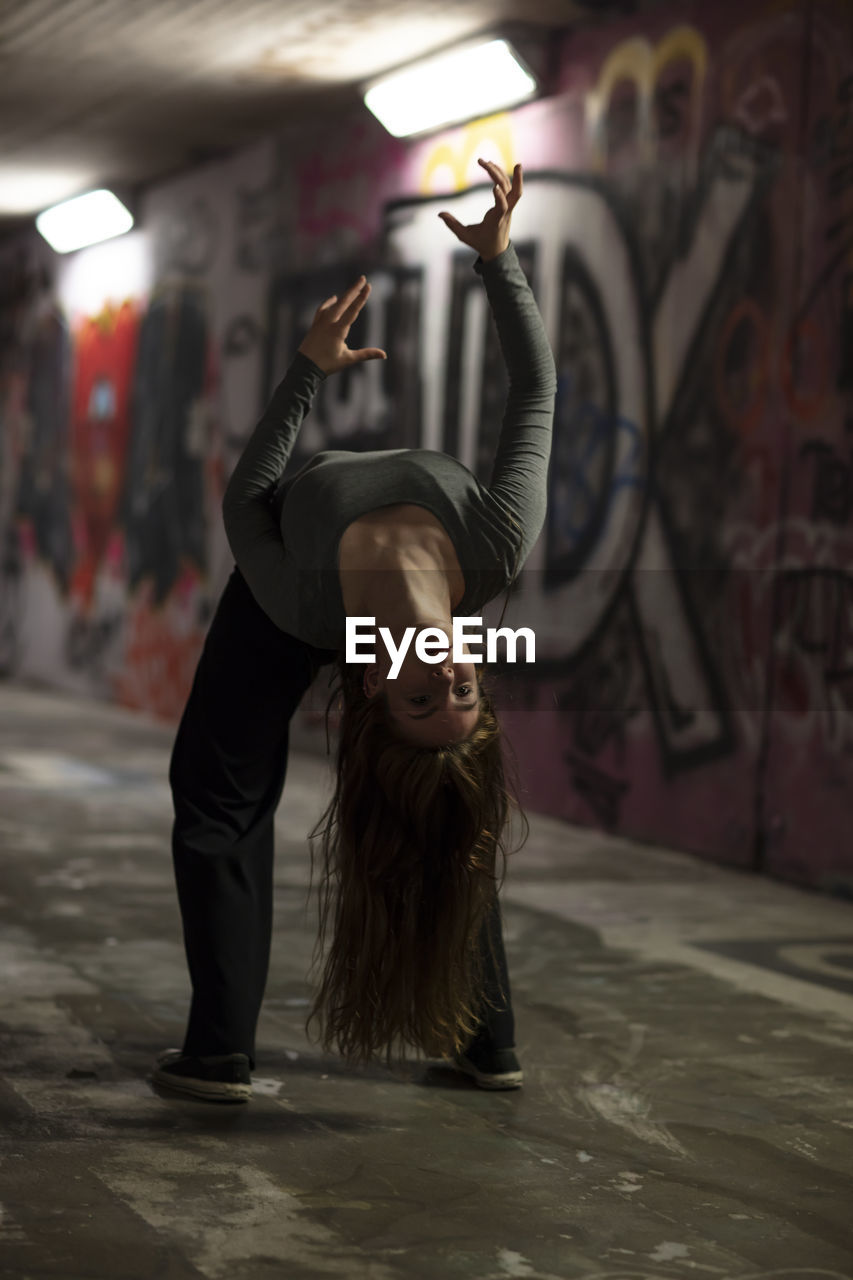 Full length of woman doing stunt in tunnel