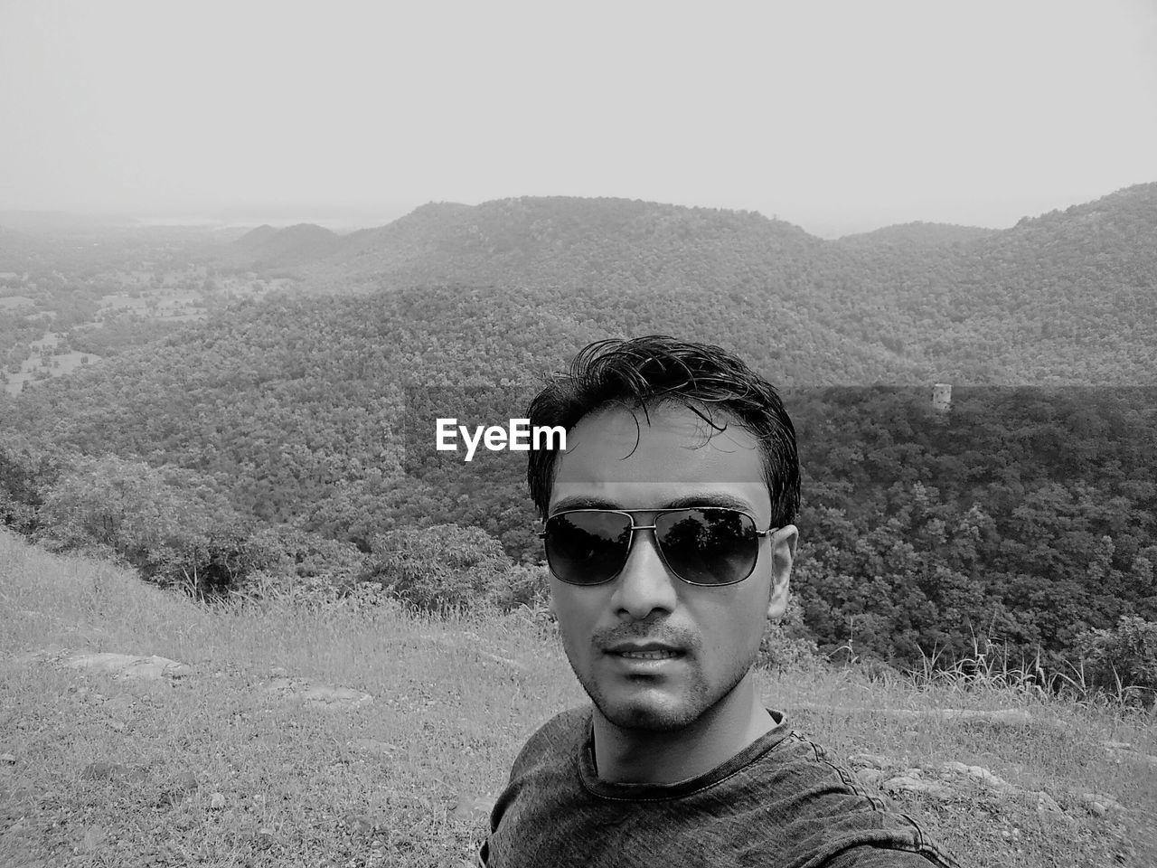 PORTRAIT OF YOUNG MAN IN SUNGLASSES AGAINST SKY