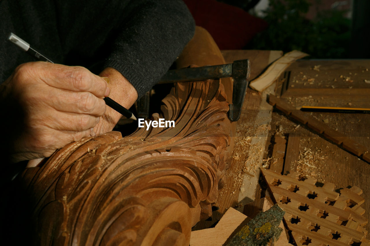 cropped hands of man working on wood