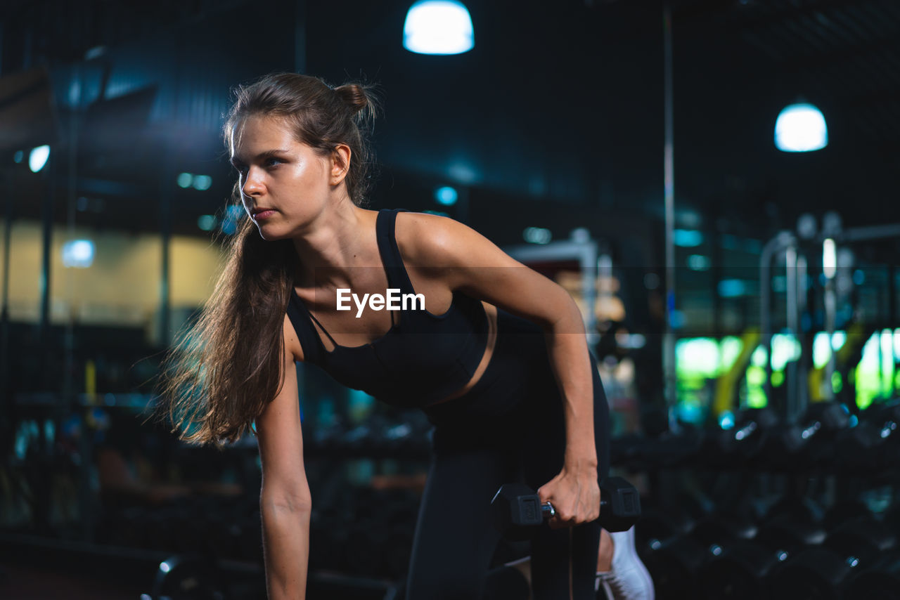 portrait of young woman exercising in gym