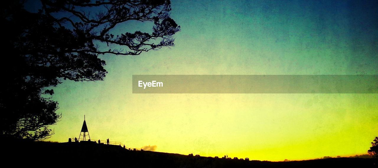 Silhouette field against sky during sunset