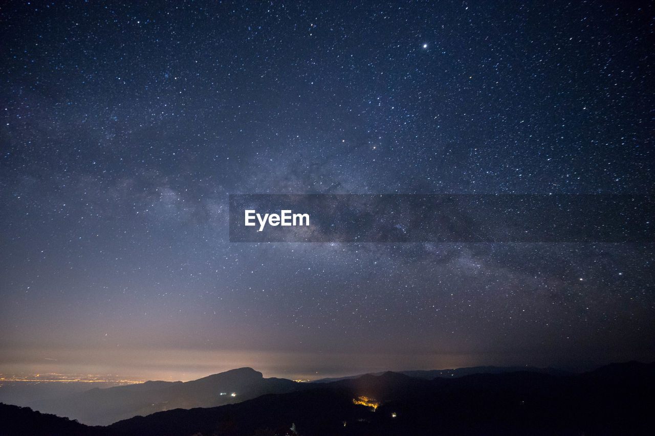 SCENIC VIEW OF MOUNTAIN AGAINST STAR FIELD