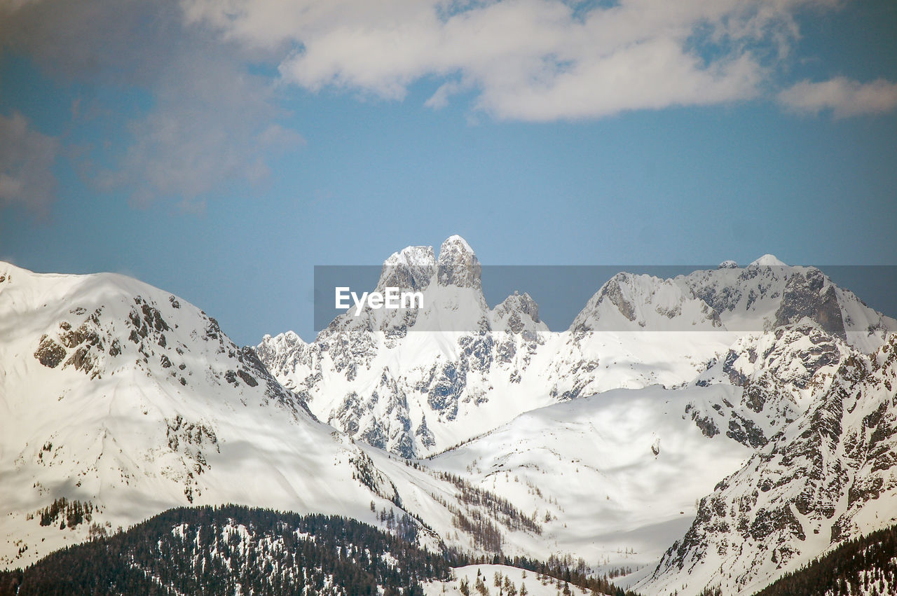 Low angle view of snowcapped mountains against sky