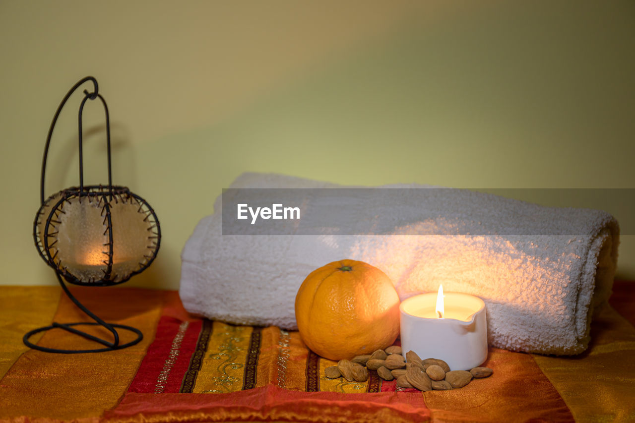 Towel with candle and warm lamp. massage with oil and candles. massage therapy for one person. 