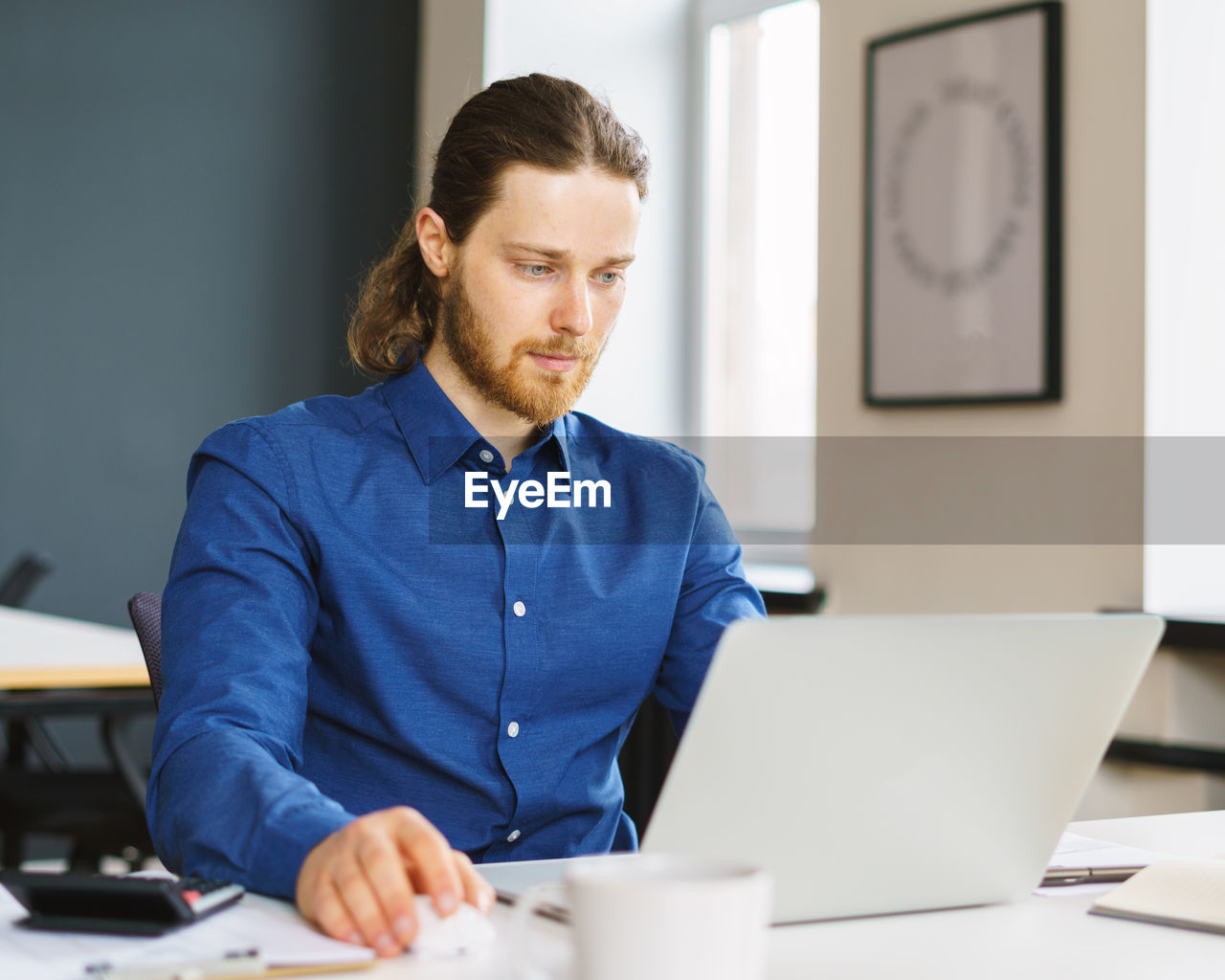 Young focused man freelancer working on laptop computer remotely