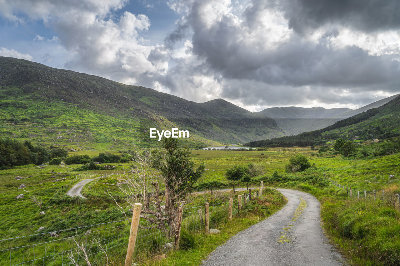 Winding country road leading trough black valley, macgillycuddys reeks mountains, ireland